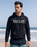 CULTUR black microfiber performance polyester hoodie with white logo and camo sleeve accents, worn by a man on a beach.