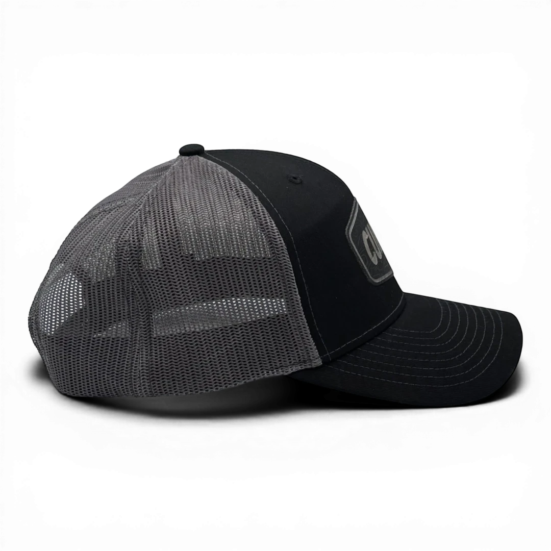 CULTUR black trucker hat with grey mesh back and embroidered CULTUR Topo patch