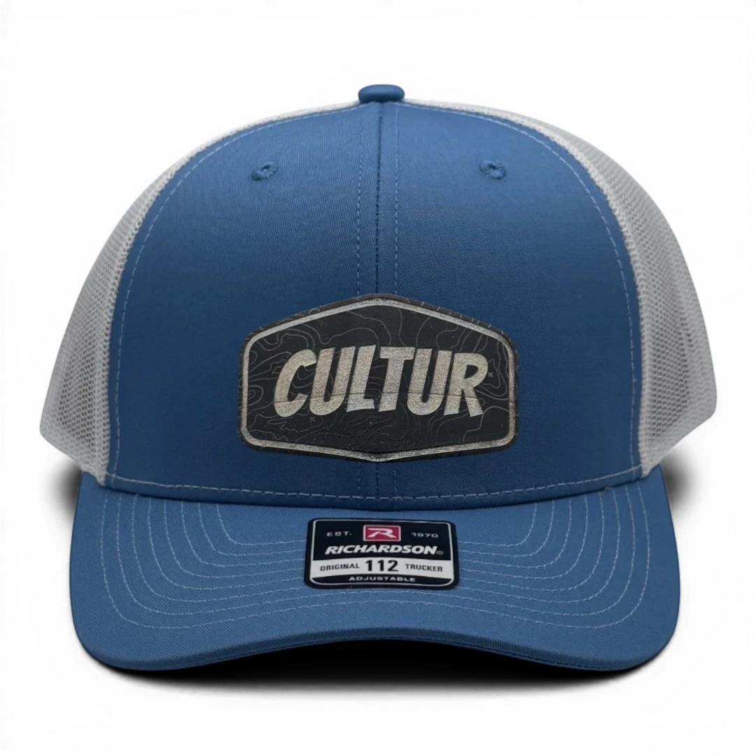 CULTUR blue trucker hat with white mesh back and topographic patch