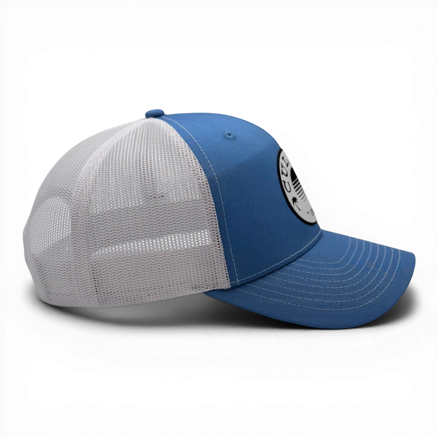 CULTUR blue trucker hat with white mesh back and circular CULTUR patch on front.