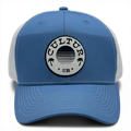CULTUR blue trucker hat with white mesh back and circular patch featuring palm trees and a sunset design.